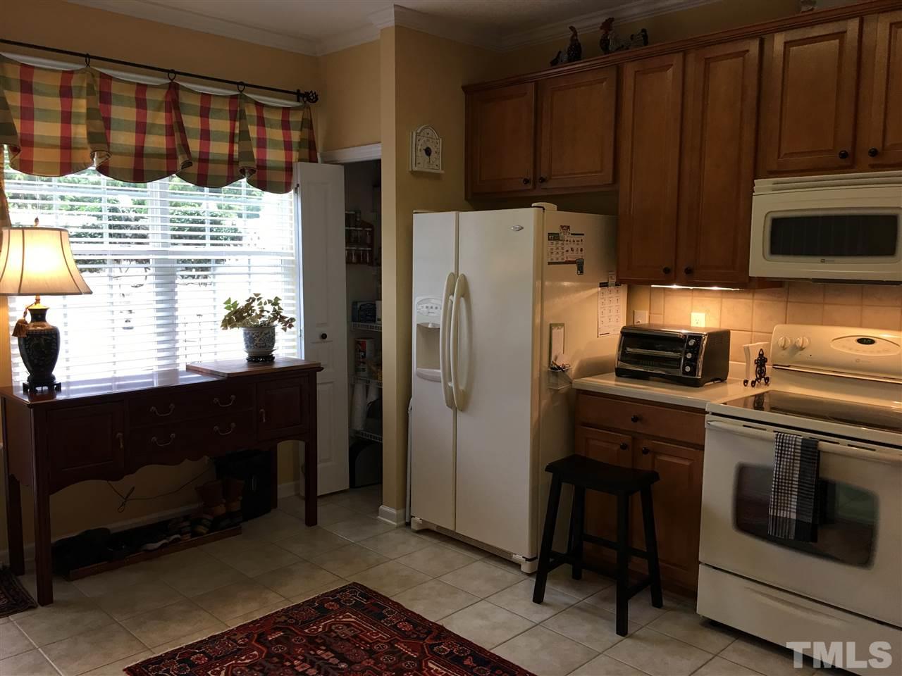 7634 Winners Edge Street Raleigh, NC 27617 - Photo 7 of 22 a kitchen with granite countertop a refrigerator stove and microwave