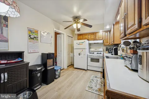 a kitchen with stainless steel appliances granite countertop a stove refrigerator and a view of living room