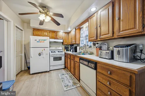 a kitchen with stainless steel appliances granite countertop a refrigerator a stove and a sink with dishwasher
