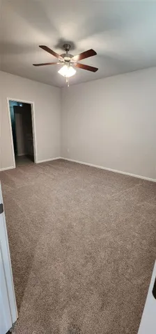 a view of an empty room with a chandelier fan