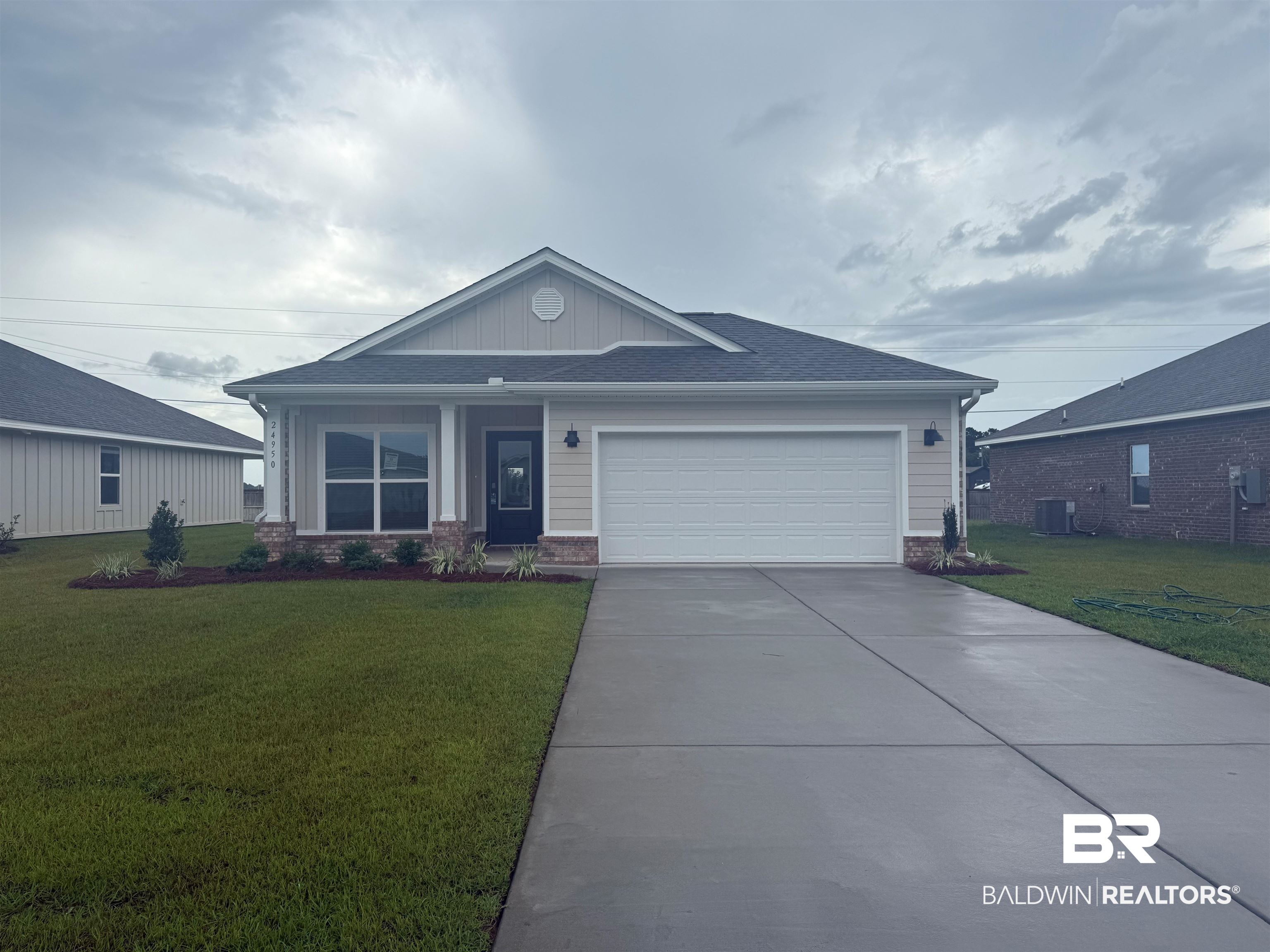 24950 Ponder Loop Loxley, AL 36551 - Photo 1 of 45 View of front of property featuring an attached garage, a front yard, concrete driveway, and board and batten siding