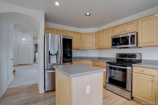 a kitchen with a stove a sink dishwasher and a refrigerator