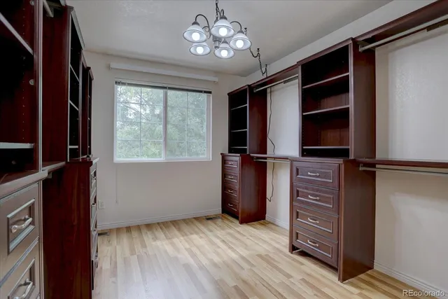 a view of walk in closet with clothes and shoes