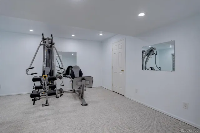 a room with gym equipment and wooden floor