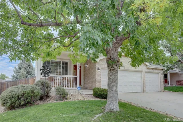 front view of a house with a yard and an trees