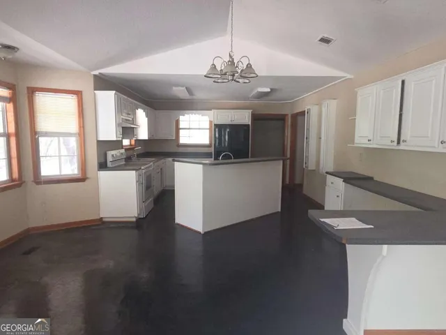 a kitchen with stainless steel appliances granite countertop a stove and a wooden floors