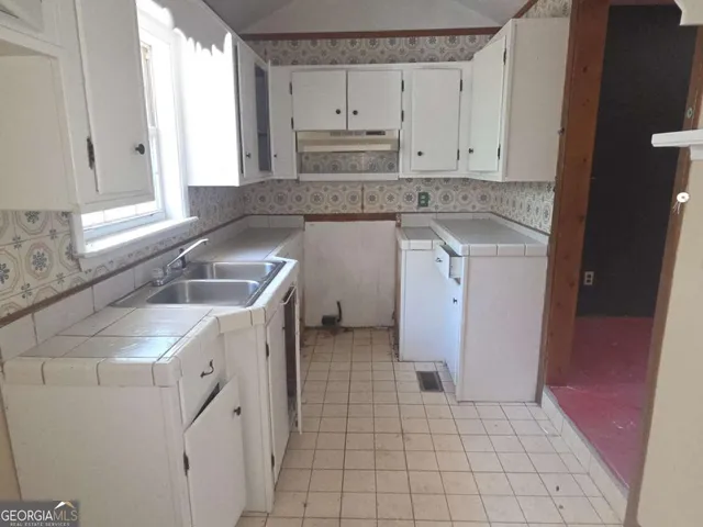 a kitchen with a sink stove and cabinets