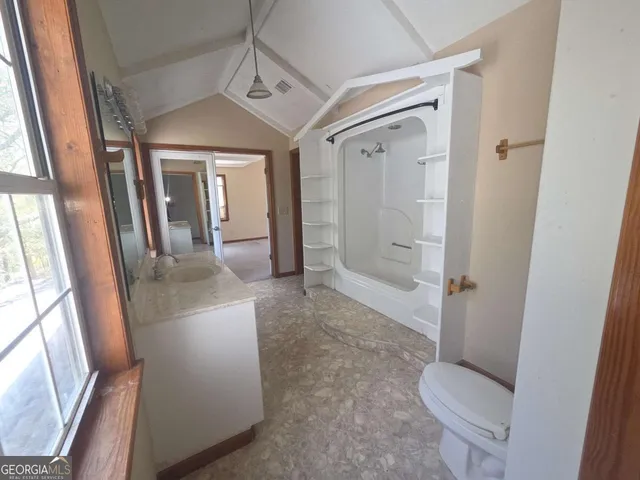 an empty room with a windows and a ceiling fan