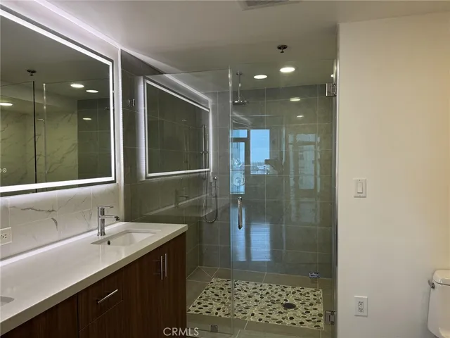 a bathroom with a sink shower and a mirror