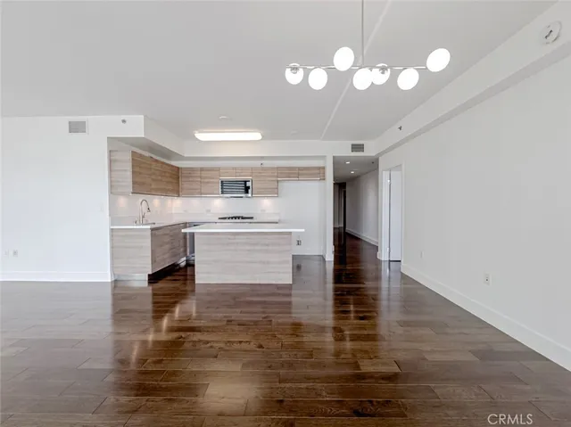 a kitchen with kitchen island a counter top a stove and cabinets