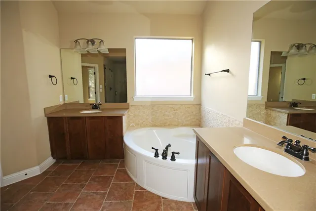 a bathroom with a bathtub sink and mirror