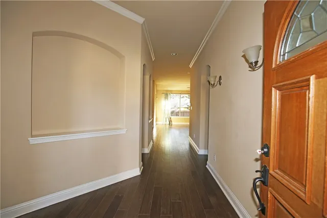 a view of a hallway with wooden floor and staircase