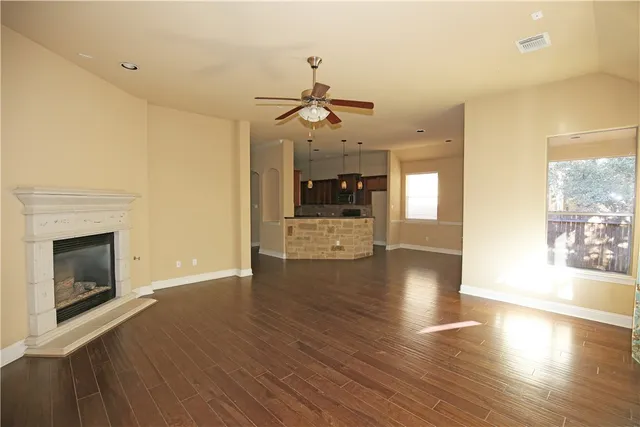 a view of a livingroom with a fireplace wooden floor and windows