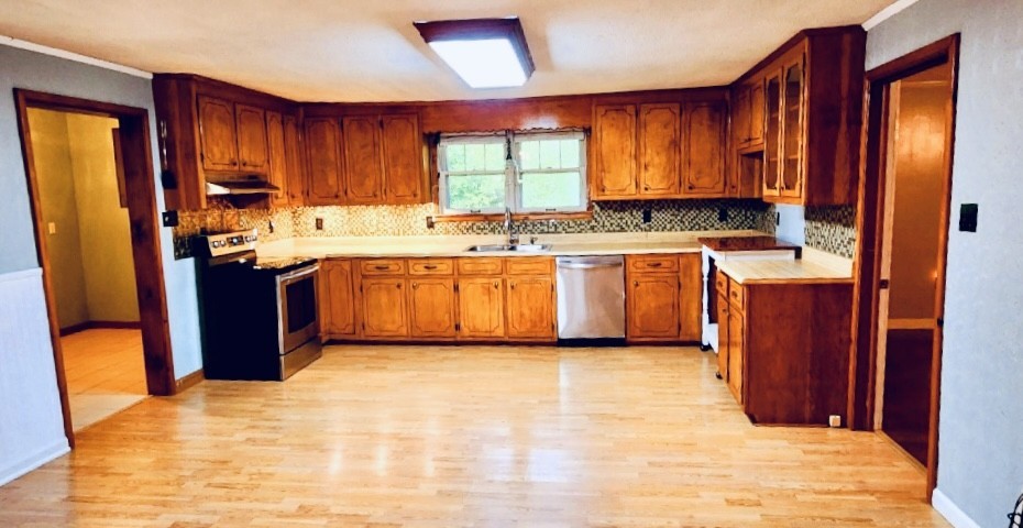 701 Littrell Road Loretto, TN 38469 - Photo 8 of 22 a kitchen with stainless steel appliances granite countertop wooden cabinets a sink dishwasher and a refrigerator