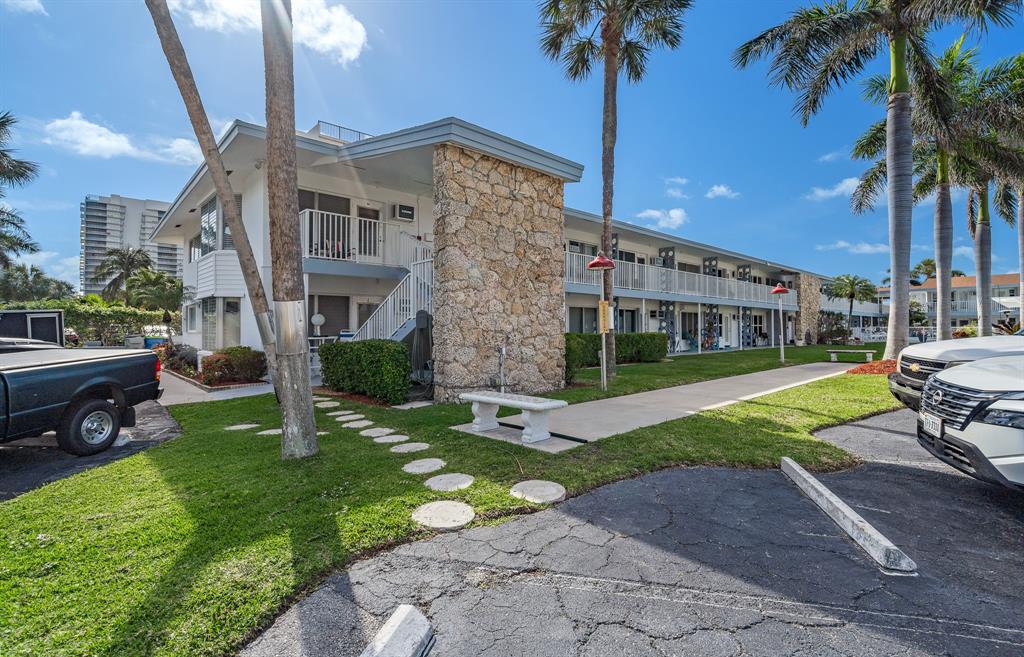 1110 North Riverside Drive, Unit 20 Pompano Beach, FL 33062 - Photo 2 of 32 a view of a house with a yard and palm trees