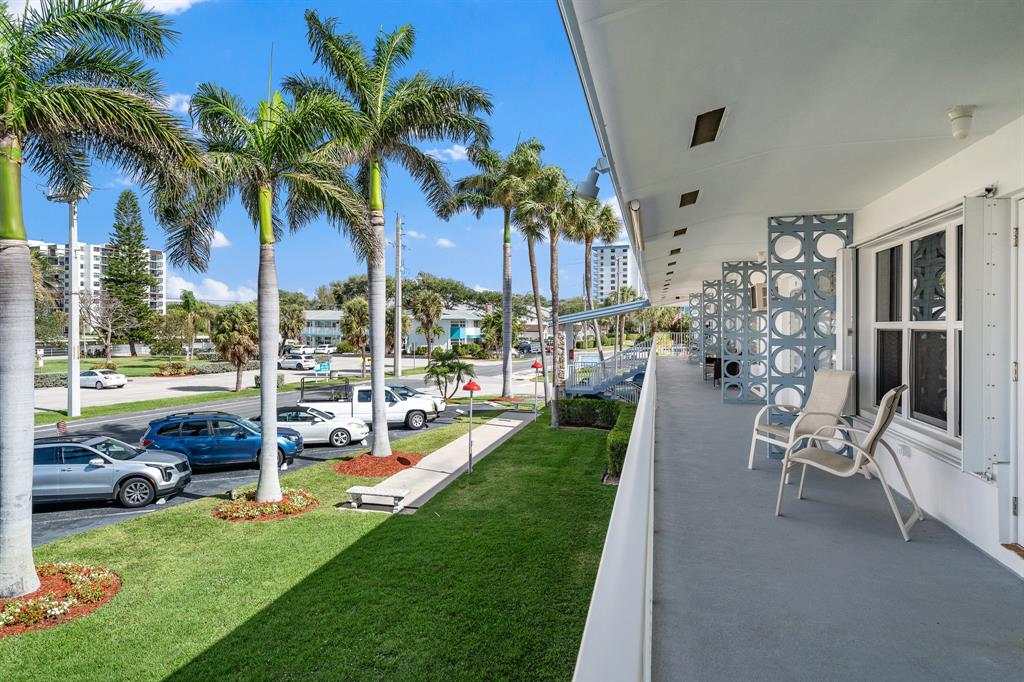 1110 North Riverside Drive, Unit 20 Pompano Beach, FL 33062 - Photo 28 of 32 a view of a patio with table and chairs potted plants and palm trees