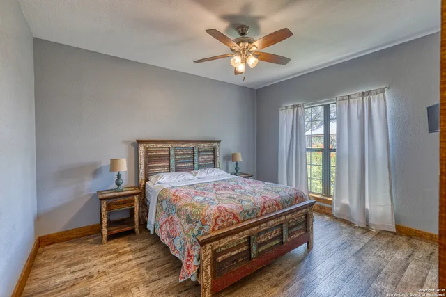 a bedroom with a bed a chandelier and a window