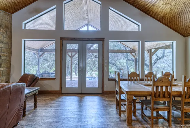 a view of a dining room with furniture large windows and wooden floor