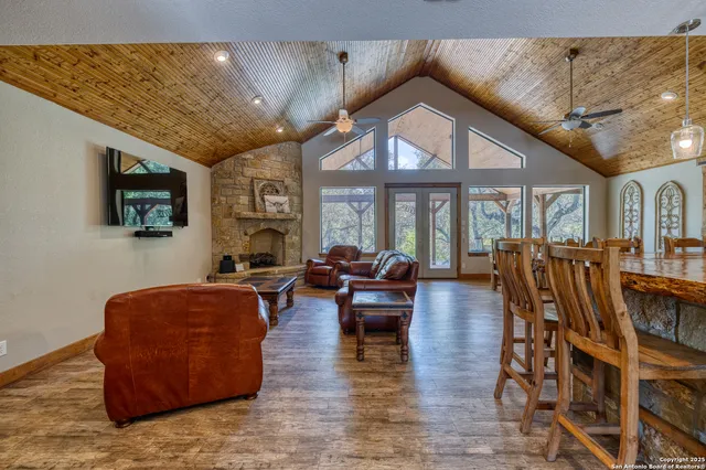 a living room with furniture a flat screen tv and large windows