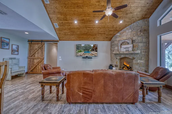 a living room with furniture a fireplace and wooden floor