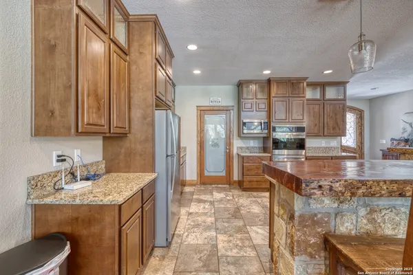 a kitchen with kitchen island granite countertop wooden cabinets and stainless steel appliances