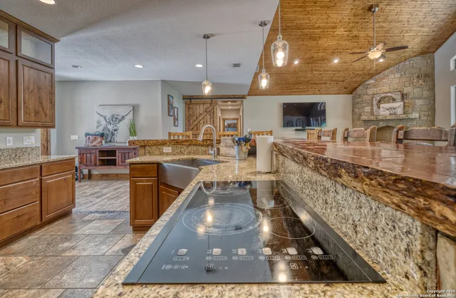 a large kitchen with stainless steel appliances kitchen island granite countertop a large counter top couches and kitchen view