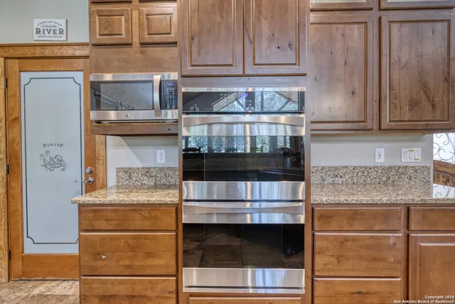 a kitchen with stainless steel appliances granite countertop white cabinets and a counter top space