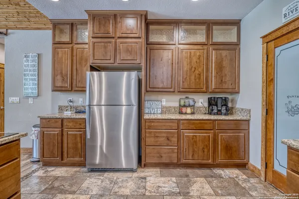 a kitchen with stainless steel appliances granite countertop a refrigerator and a sink