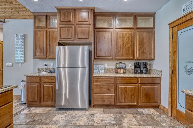 a kitchen with stainless steel appliances granite countertop a refrigerator and a sink