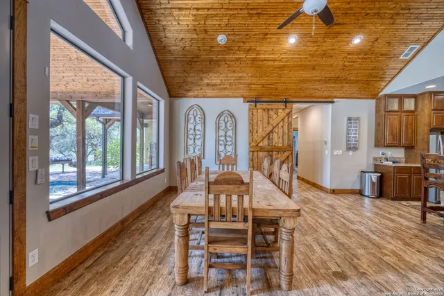 a view of a livingroom with furniture wooden floor windows and a ceiling fan