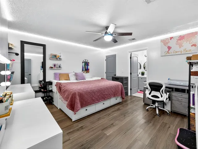 a spacious bedroom with a bed a desk and chair