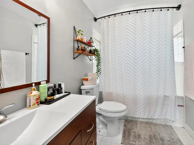 a bathroom with a sink a toilet and shower curtain