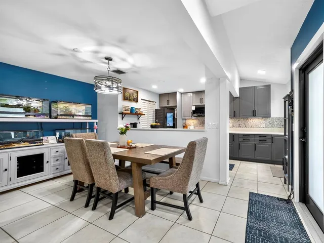 a dining area with stainless steel appliances kitchen island granite countertop a dining table and chairs