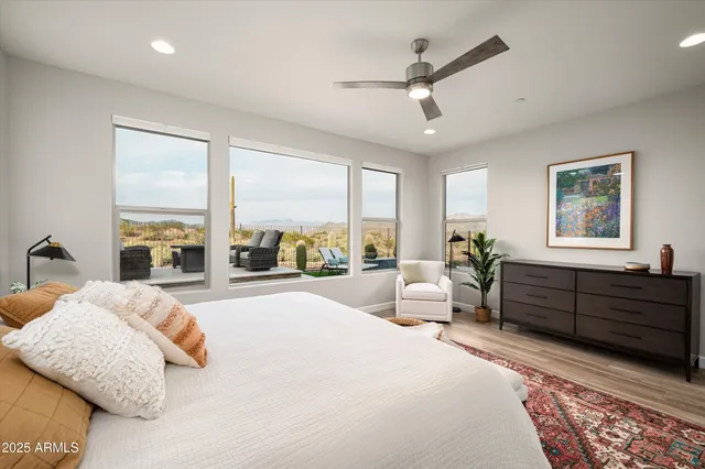 a spacious bedroom with a bed a couch and a large window