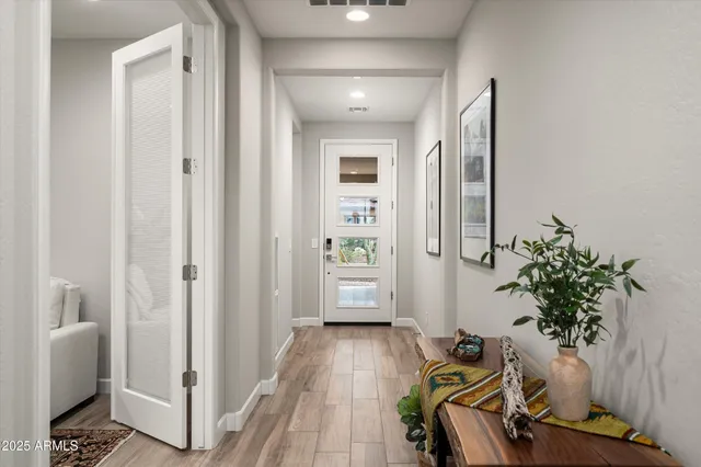 a view of a hallway with wooden floor and a potted plant