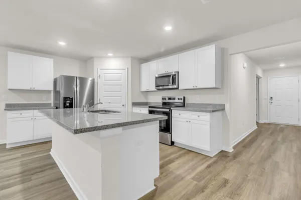 a kitchen with stainless steel appliances granite countertop a stove a sink and a refrigerator