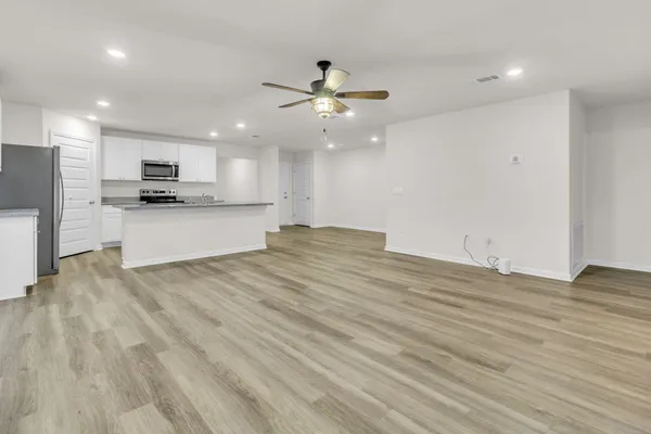 a view of kitchen with granite countertop cabinets and refrigerator