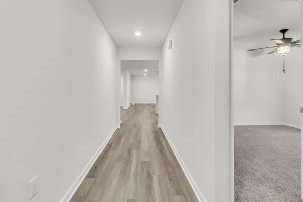 a view of a hallway with wooden floor