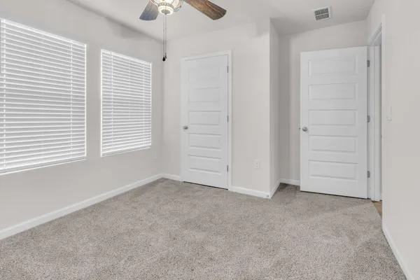 an empty room with windows and closet