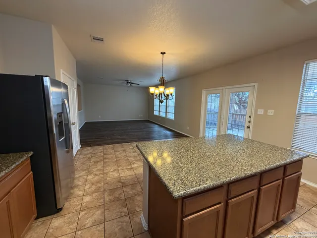 a kitchen with kitchen island a counter top space and a refrigerator