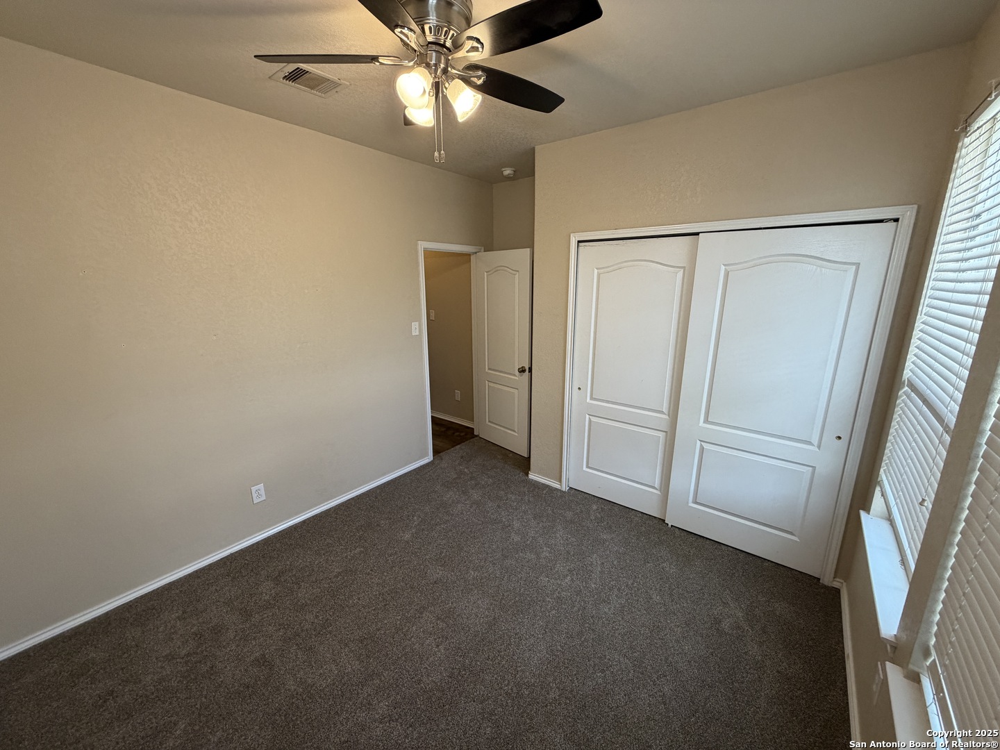 20803 Foothill Pine San Antonio, TX 78259 - Photo 6 of 9 an empty room with closet and a chandelier fan