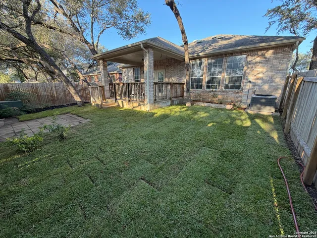 a view of a big house with a big yard and large tree