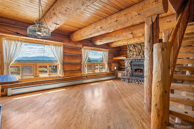 a view of a livingroom with wooden floor and a fireplace