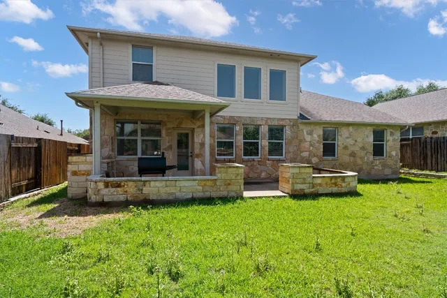 a view of a house with a backyard and a patio