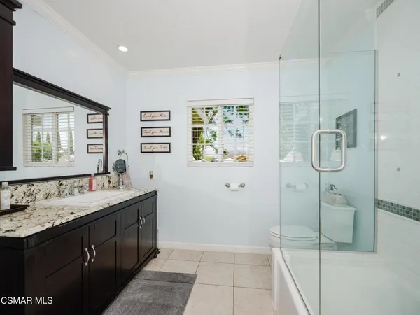 a bathroom with a double vanity sink mirror and shower