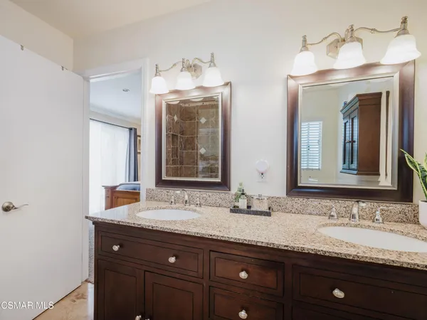 a bathroom with double vanity sinks and a mirror