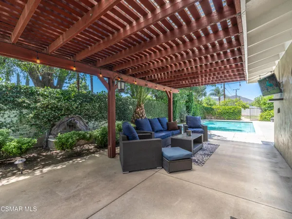 a view of a patio with couches and plants with wooden fence
