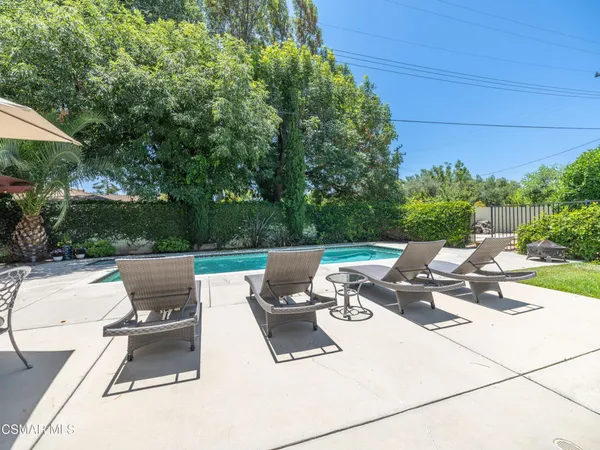 a view of a patio with table and chairs under an umbrella