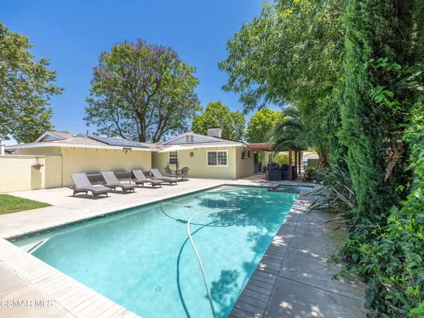 a view of a backyard with table and chairs under an umbrella