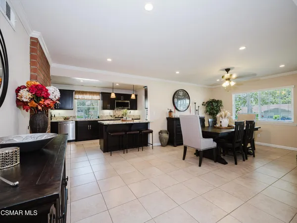 a living room with furniture a chandelier and a dining table with wooden floor